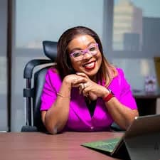 Mabel Adeteye at her desk in a magenta blazer